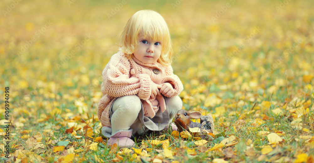 Little child sitting playing with yellow leaves in autumn park Little child sitting playing with yellow leaves in autumn park