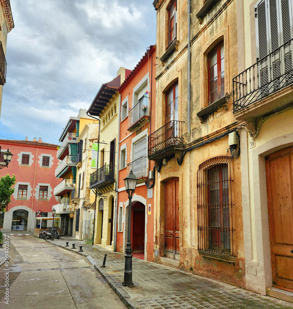 Fototapeta premium Narrow streets of the old town. Beautiful colorful facades with gates and balconies. Arenys de Mar. Catalonia. Spain.