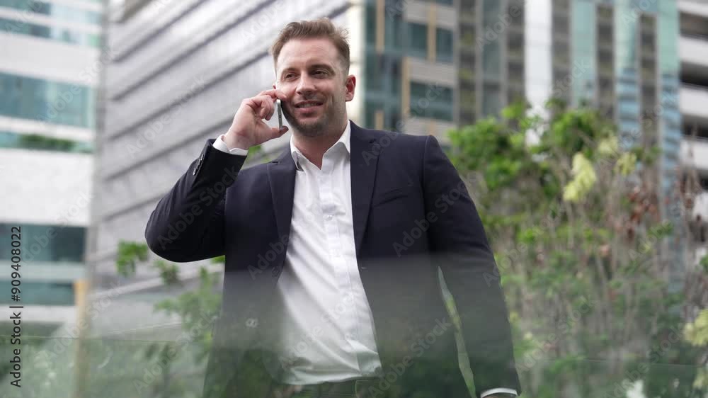 Successful businessman standing at rooftop while talking with marketing team about investment by using phone. Caucasian investor enjoy relaxing by looking at modern skyscraper view. Lifestyle. Urbane