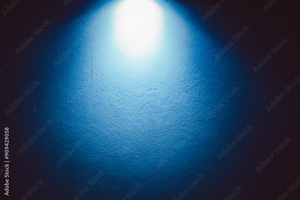 Fotografie A blue wall with a white light shining on it