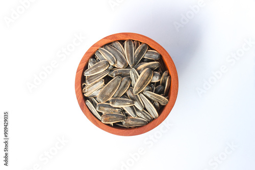 Kwaci or Sunflower Seeds, snack made from dried and salted sunflower seeds in a wooden bowl isolated on white background photo