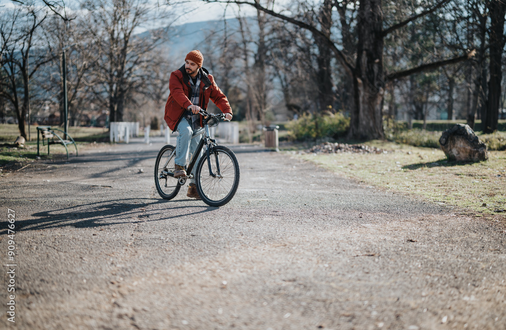 A modern hipster man on a leisurely bicycle ride, taking in the serenity of the outdoor park setting. A modern hipster man on a leisurely bicycle ride, taking in the serenity of the outdoor park setting.