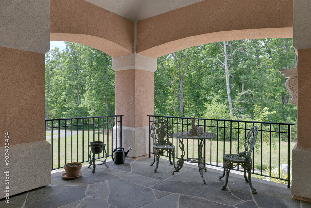 Φωτογραφία Stone Tile Terrace With Wrought Iron Furniture Set Under Covered Porch View