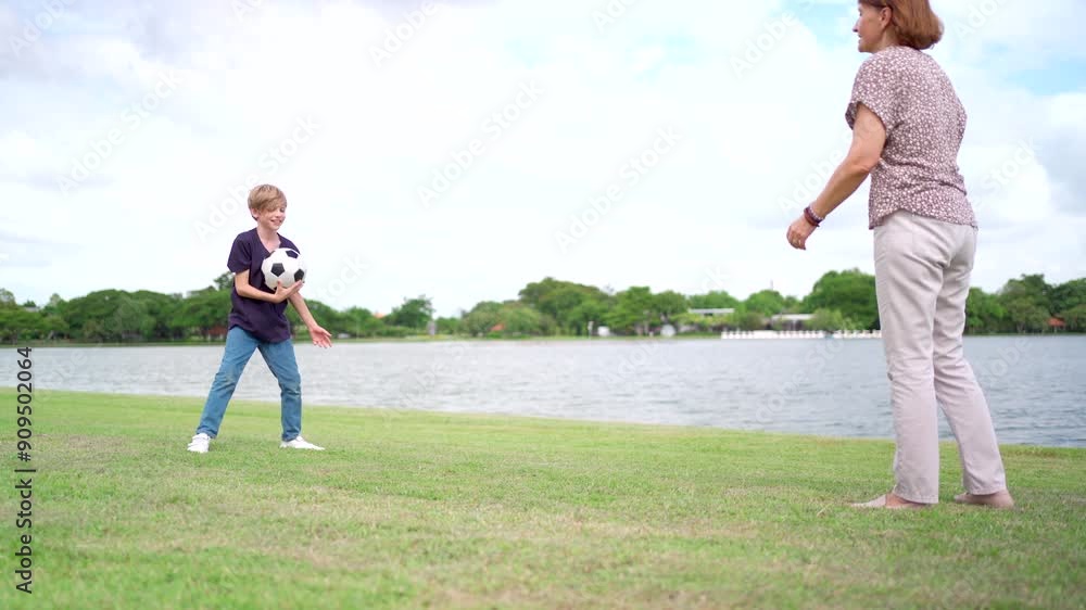 Lovely little boy and mother enjoy playing football at the park. Lovely little boy and mother enjoy playing football at the park.