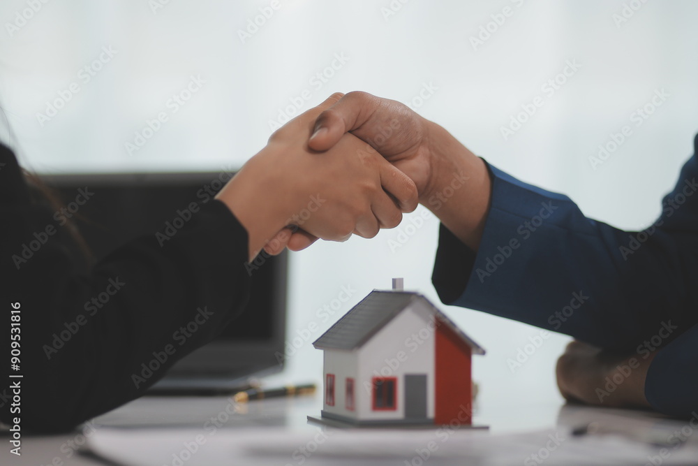 Estate agent shaking hands with customer after contract signature Estate agent shaking hands with customer after contract signature
