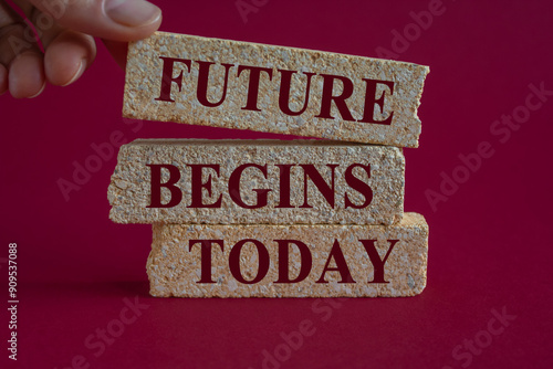 Concept words Future begins today on brick blocks. Beautiful red background, businessman hand. Motivational inspirational quote.