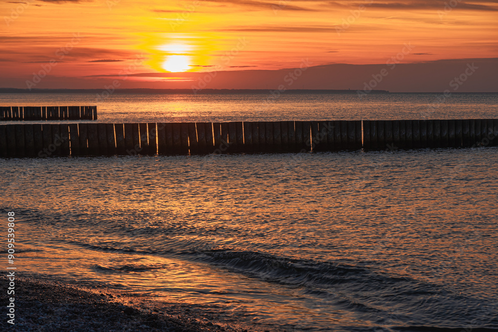 View of sand beach with wooden breakwaters on the Baltic Sea coast on sunset in Zelenogradsk. Russia