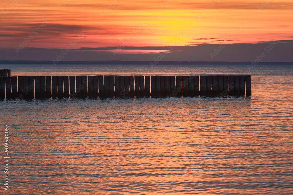 Φωτογραφία View of sand beach with wooden breakwaters on the Baltic Sea coast on sunset in Zelenogradsk