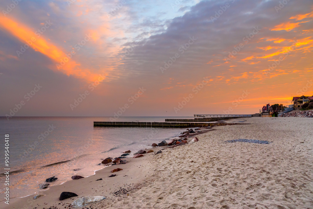 View of sand beach with wooden breakwaters on the Baltic Sea coast on sunrise in Zelenogradsk. Russia