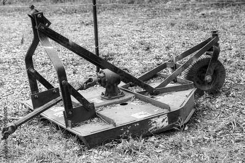 Black and white of a bush hog brush cutter on a farm.