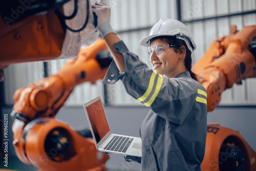 Engineer woman working in advance machine factory. Indian female engineering staff work checking robot arm in assembly plant