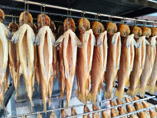 Many delicious golden smoked fish on the smokehouse shelf 