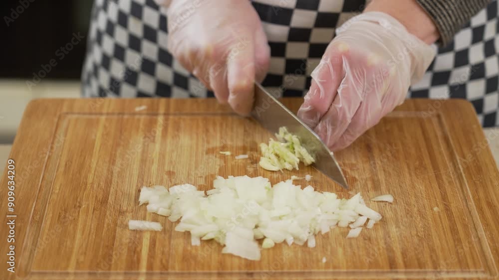 Chopping onion and garlic with a knife on the cutting board Chopping onion and garlic with a knife on the cutting board