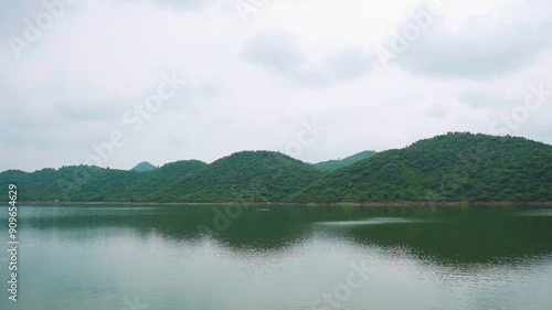 View of Badi lake with green hills at Udaipur, Rajasthan, India. Serene calm lake at Udaipur during monsoon season. Man made water reservoir. Travel and holidays concept. photo