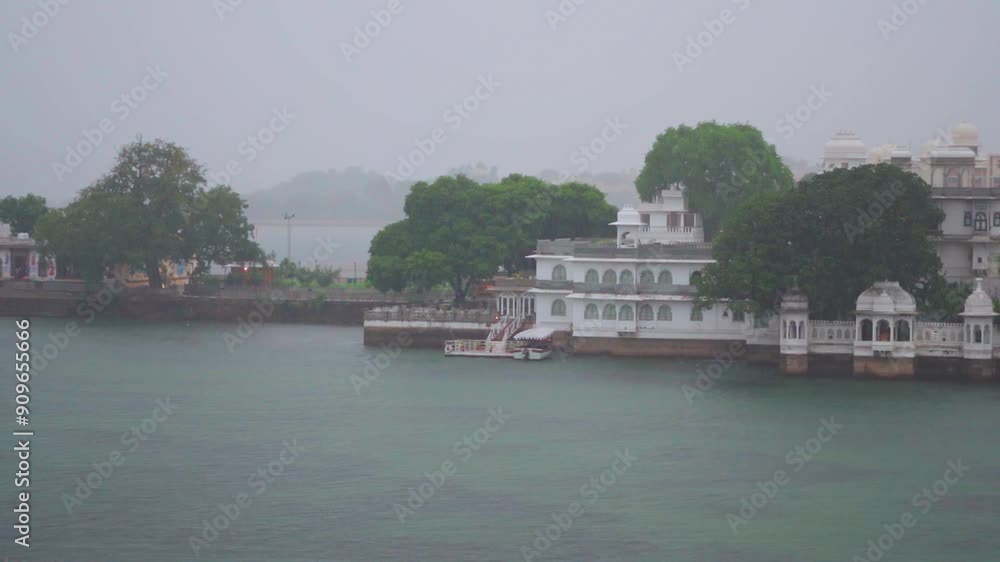 Slow Motion shot of Udaipur city and lake Pichola in heavy rain. Heavy rain falling on lake during monsoon season. Heavy downpour during day at Ambrai Ghat in Udaipur, Rajasthan, India. Slow Motion shot of Udaipur city and lake Pichola in heavy rain. Heavy rain falling on lake during monsoon season. Heavy downpour during day at Ambrai Ghat in Udaipur, Rajasthan, India.