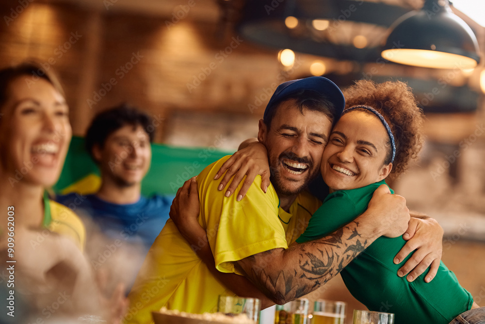 Obraz premium Happy couple of fans embracing while celebrating victory of their favorite sports team.