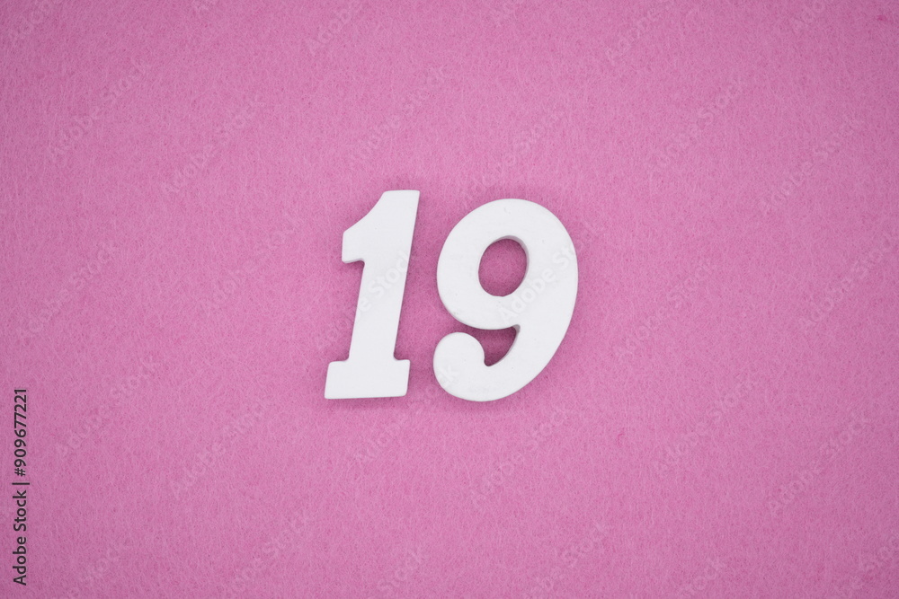 The numbers are made of white painted wood. Laying on the floor was pink paper. The numbers are made of white painted wood. Laying on the floor was pink paper.
