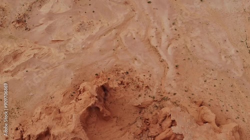 The Flaming Cliffs in the Gobi Desert, Mongolia, under a clear blue sky, showcasing its iconic red sandstone formations and barren landscape.