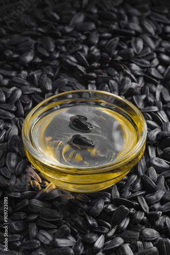 Sunflower seeds background and sunflower oil in glass bowl close up of roasted seeds top view