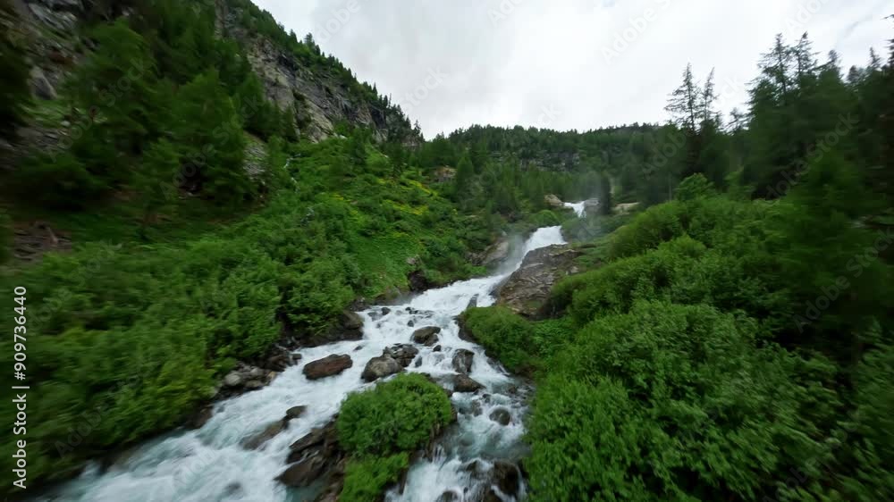 Cascading Rutor Waterfall amidst lush green forest in Aosta Valley, Italy, aerial view Cascading Rutor Waterfall amidst lush green forest in Aosta Valley, Italy, aerial view