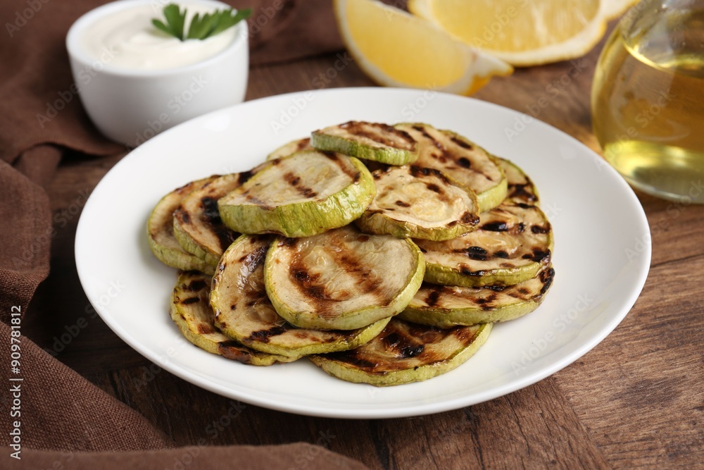 Tasty grilled courgette slices on wooden table Tasty grilled courgette slices on wooden table