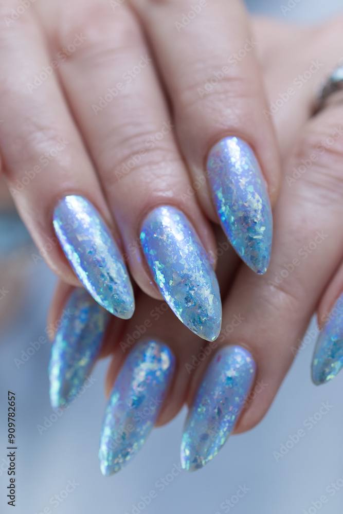 Female hand with long nails and bright light blue and silver manicure Female hand with long nails and bright light blue and silver manicure