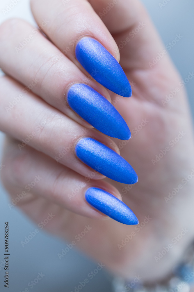 Woman's beautiful hand with long nails and bright blue manicure Woman's beautiful hand with long nails and bright blue manicure