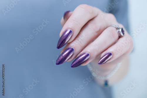 Beautiful woman's hand with long nails and multicolored nail polish, purple and brown  photo