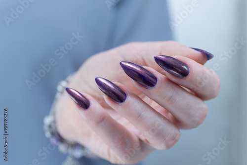 Beautiful woman's hand with long nails and multicolored nail polish, purple and brown  photo