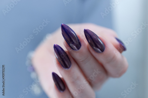 Beautiful woman's hand with long nails and multicolored nail polish, purple and brown  photo