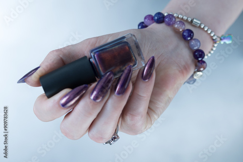 Beautiful woman's hand with long nails and multicolored nail polish, purple and brown  photo