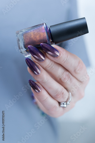 Beautiful woman's hand with long nails and multicolored nail polish, purple and brown  photo