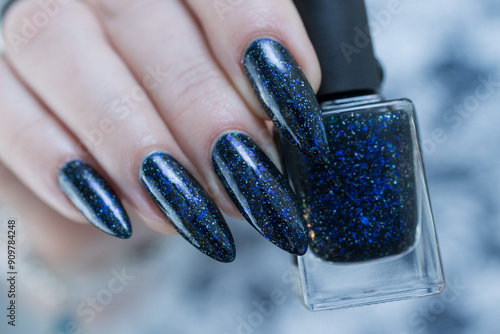 Woman's hand with long nails black and dark blue manicure photo