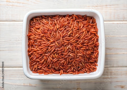 Fresh, raw, organic red rice washes in a white container, viewed from above, showcasing a healthy, natural, and nutritious staple for a balanced diet.