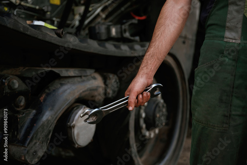 Holding wrench. Mechanic's hand fixing machinery in workshop