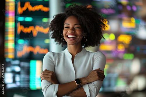 Successful Afro American business woman smiling celebrating investment stock market financial benefits results in office with data graphs screens. Success, profits concept