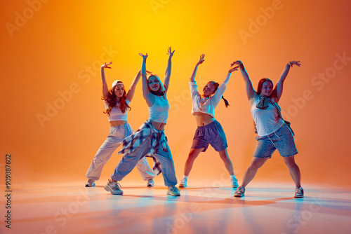 Photography Dancers in casual outfits dance contemp synch against bright orange backdrop, shows unique styles and vibrant dance moves