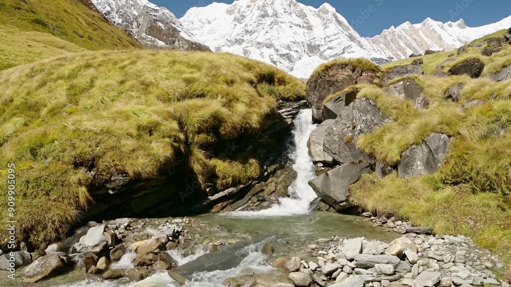 Waterfall Stream and Himalayas Mountains in Nepal, Snowcapped Mountain Top Landscape and Flowing River Scenery in High Altitude Terrain in Annapurna Region at Annapurna Base Camp Waterfall Stream and Himalayas Mountains in Nepal, Snowcapped Mountain Top Landscape and Flowing River Scenery in High Altitude Terrain in Annapurna Region at Annapurna Base Camp