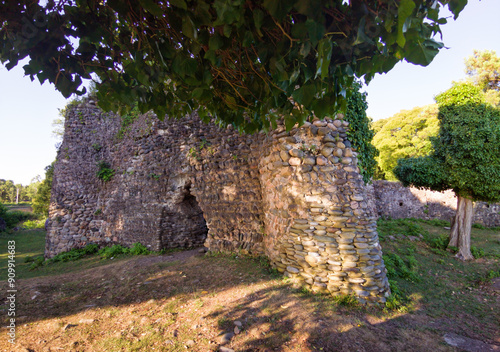 Genoese castle ruins at Black Sea in Abkhazia. Old medieval stone fortress in Kyndig village in summer. Concept of travel, landmark, historical architecture, nature, rock photo