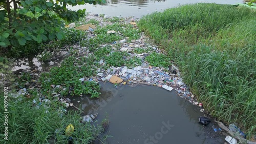 Aerial footage of pollution along the Isabela River, showing plastic waste, black water flowing from a stream, and an area affected by pollution with white spots of debris and environmental damage photo