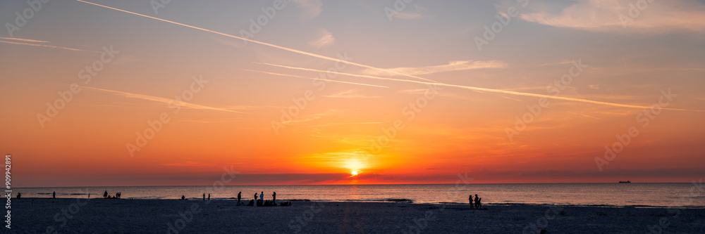 Beautiful sunset over the Baltic Sea. Silhouettes of people walking on the beach. Slajszewo, Poland
