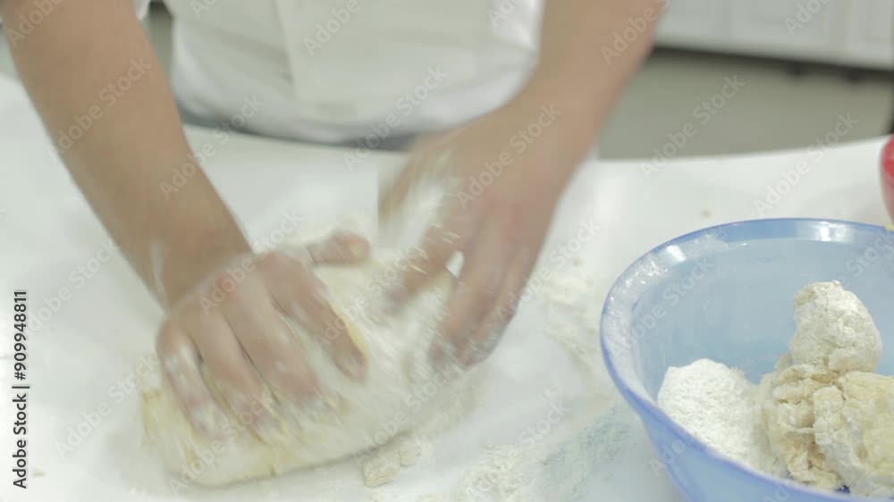 Baker is kneading dough on the flour on the table in slow motion. No people only hands. Baker is kneading dough on the flour on the table in slow motion. No people only hands.