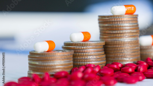 White and orange capsules on a pile of coins and pills, meaning health insurance, medical expenses and pharmaceutical, finance, saving money, business, financial and medical healthcare concept.