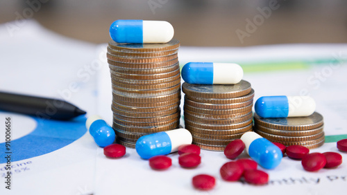 Blue and white capsules on a pile of coins and pills, meaning health insurance, medical expenses and pharmaceutical, finance, saving money, business, financial and medical healthcare concept.