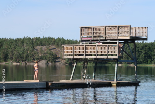 Photography Woman standing on a swimming platform in a lake in Sweden