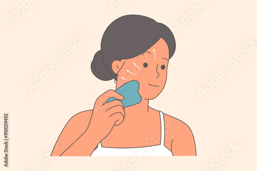 Woman makes facial massage to rejuvenate and get rid of wrinkles using gua sha device