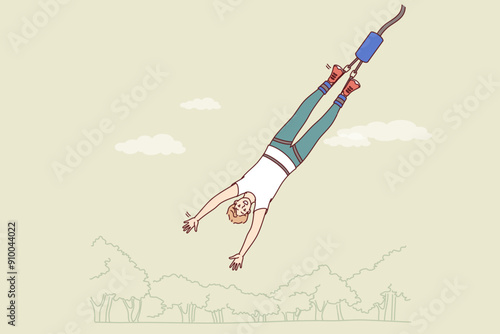 Man gets addicted to bungee jumping, enjoying extreme sport that releases adrenaline into blood. Guy who is fan of bungee jumping flies down from tall building or bridge and smiles, looking at screen