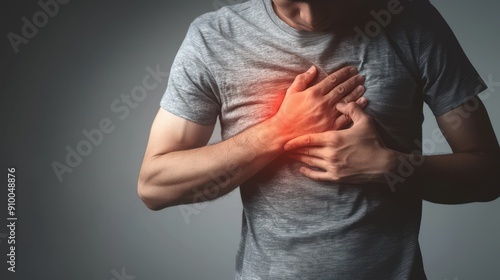 A man holding his shoulder in pain showing discomfort and his hand gripping his arm on neutral grey background, pain, shoulder ache, discomfort