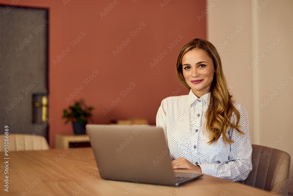 Portrait of a businesswoman posing for the camera, using a laptop. Portrait of a businesswoman posing for the camera, using a laptop.