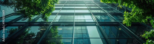 A striking view of a modern glass building surrounded by lush greenery  showcasing architectural elegance and nature s harmony.